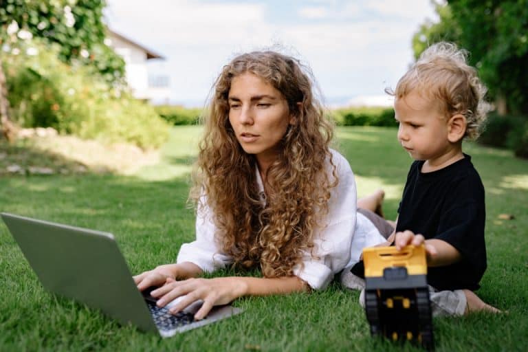 Femme avec son bébé devant un ordinateur portable pendant un congé parental