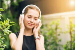 Femme avec un casque sur les oreilles écoutant des podcasts sur la reconversion professionnelle